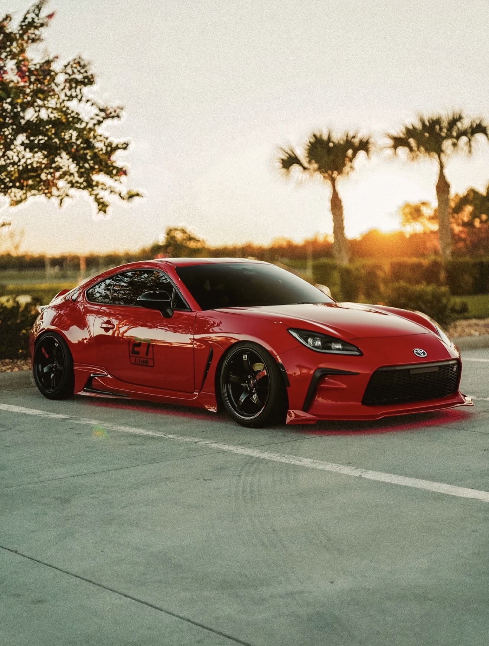 Red Toyota sports car at sunset